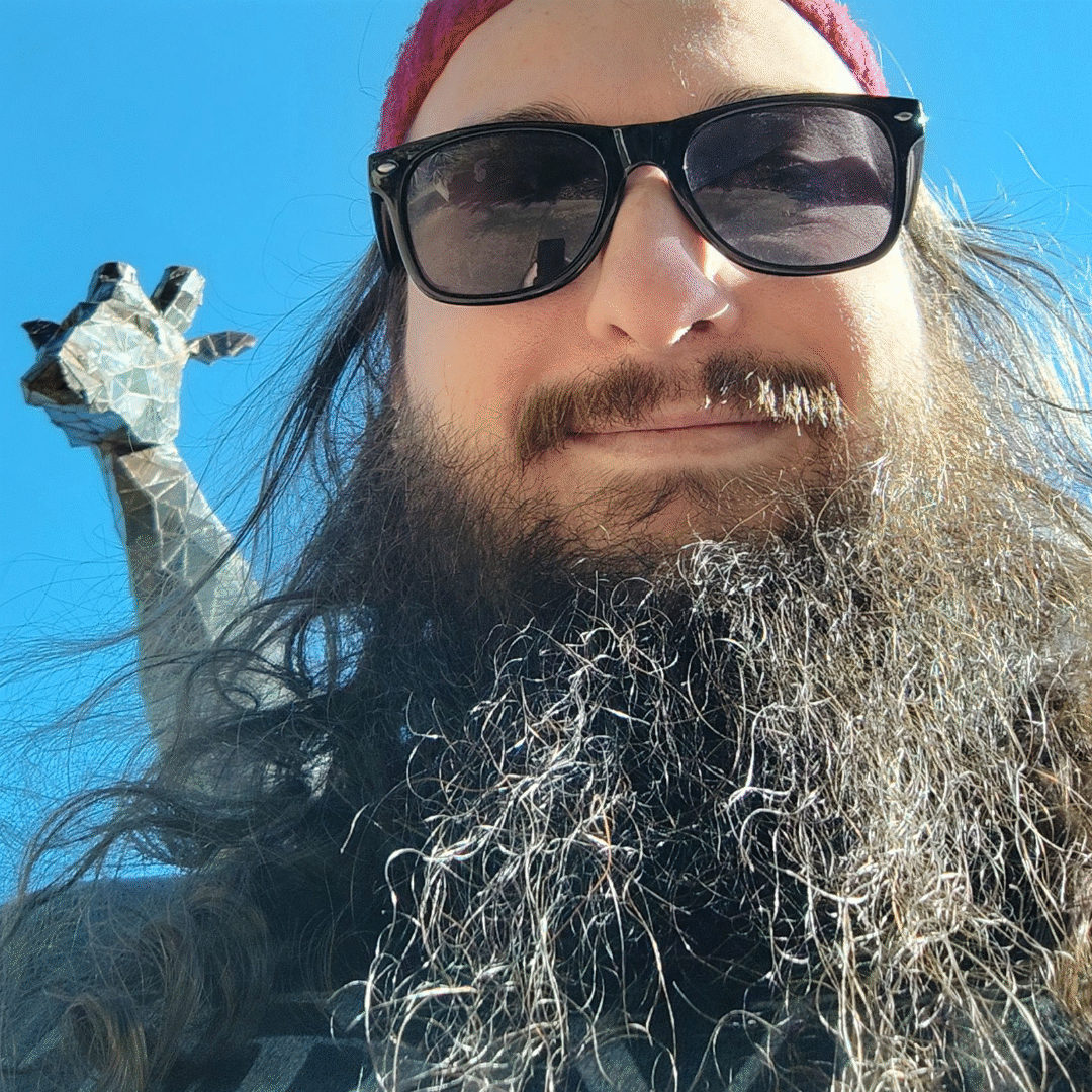 Fully bearded dev standing with a shit eating grin in front of a giraffe statue at the zoo. Celebrating our anniversary with my girlfriend Amber.